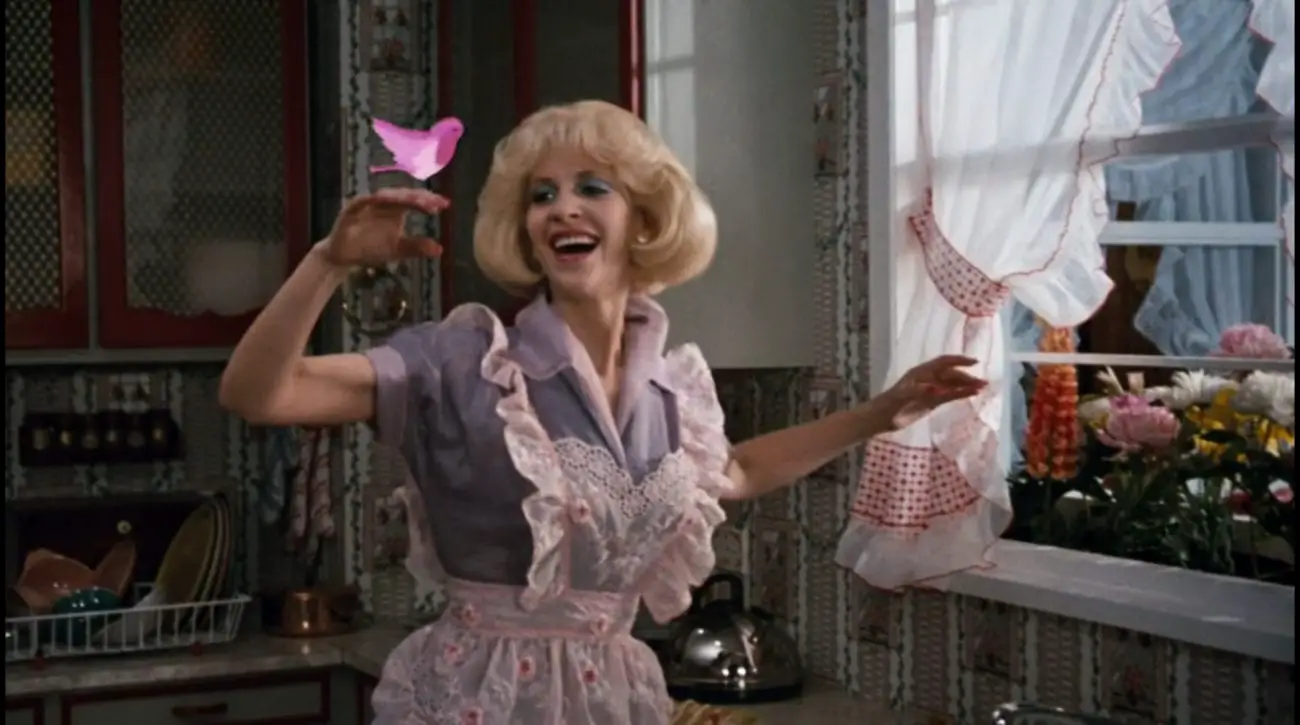 Audrey (Ellen Greene) holds up her hand, a pink animated bird perched on it, in the film, "Little Shop of Horrors" (1986).