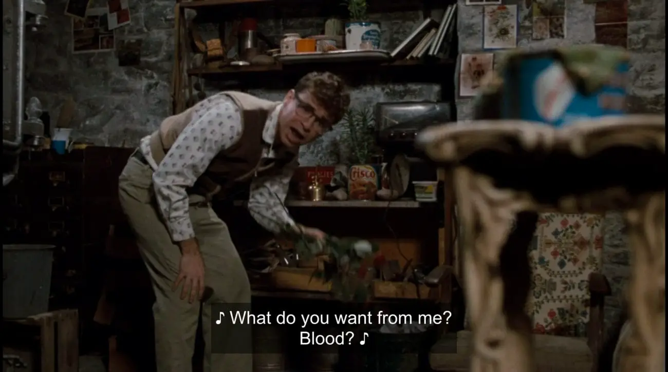 Seymour Krelborn (Rick Moranis) sings, "What do you want from me? Blood?" in the film, "Little Shop of Horrors" (1986).