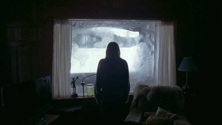Grace looks out a frosted over window