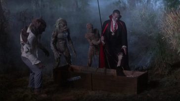 Wolfman (Jonathan Gries), Gillman (Tom Woodruff, Jr.), and the Mummy (Michael Reid MackKay) look on as Count Dracula (Duncan Regehr) reaches down toward the extended hand of the Frankenstein monster (Tom Noonan), who's lying in a crate, in the film, "The Monster Squad" (1987).