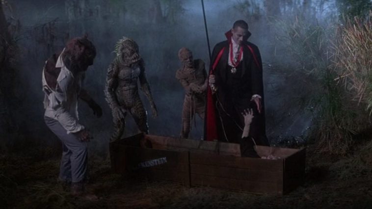 Wolfman (Jonathan Gries), Gillman (Tom Woodruff, Jr.), and the Mummy (Michael Reid MackKay) look on as Count Dracula (Duncan Regehr) reaches down toward the extended hand of the Frankenstein monster (Tom Noonan), who's lying in a crate, in the film, "The Monster Squad" (1987).