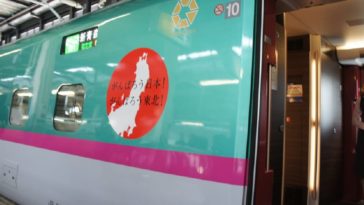 Tohoku Shinkansen Train in station with open door and attendant inside.