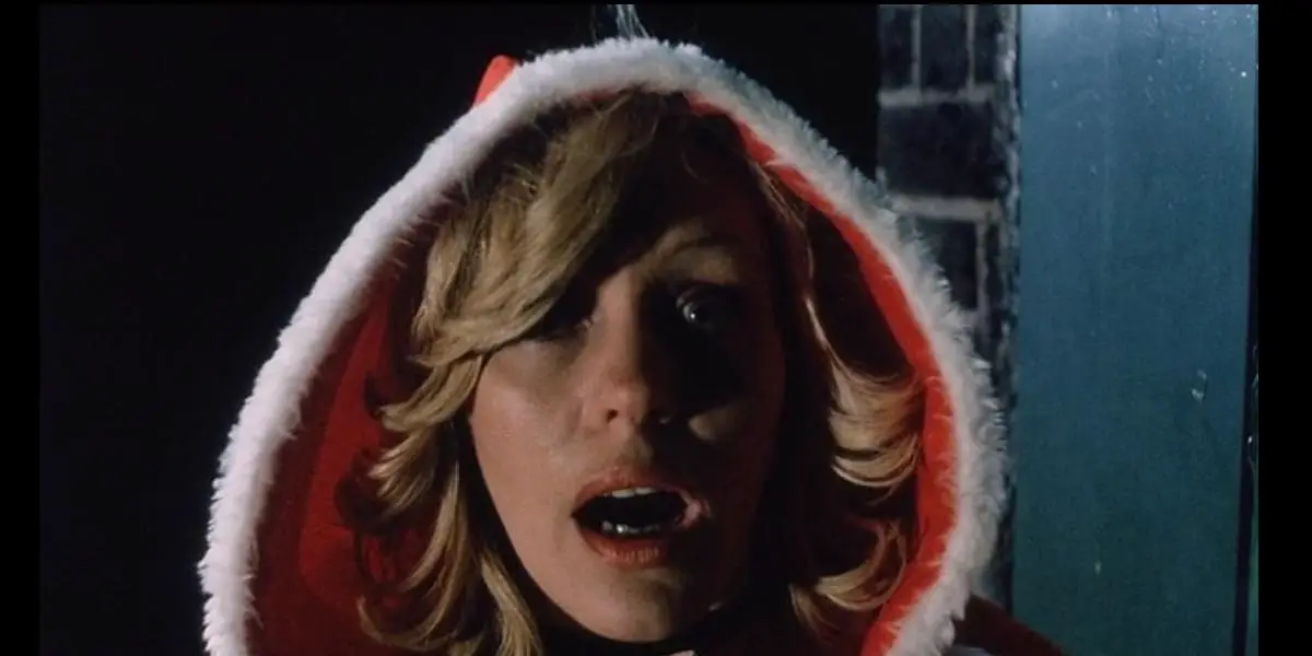 A blonde woman in a red Santa hood screams in terror.