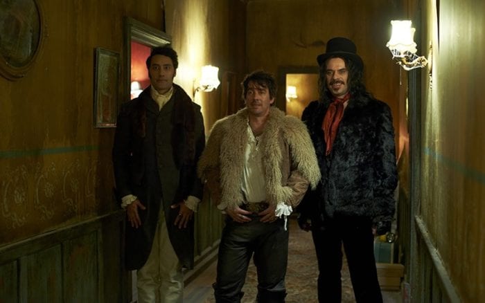 Viago, Deacon and Vladislav stand in a hallway wearing large furry coats