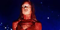 A young woman covered in blood stands straight with set mouth and wide eyes in Carrie.