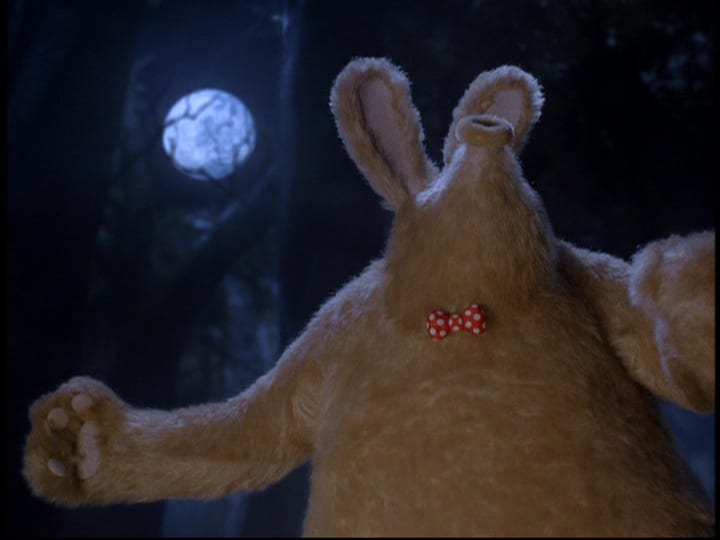 The giant brown were-rabbit (Peter Sallis), in a red bow tie with white polka dots, howls at the full moon, beating his chest, in the film, "Wallace & Gromit: The Curse of the Were-Rabbit" (2005).