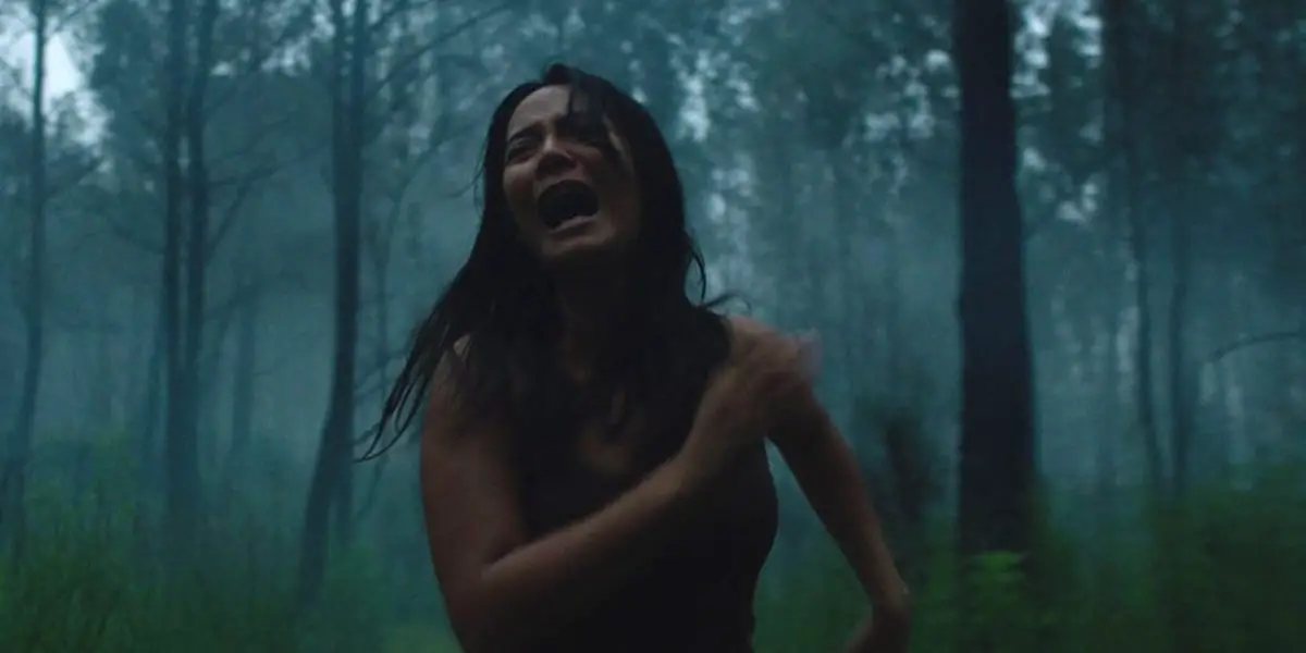 A woman runs screaming through the woods