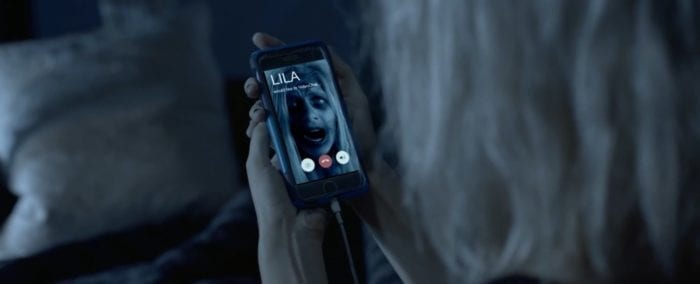Cadence holds her cell phone displaying a face time call from a dead and decaying classmate named Lila