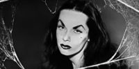 Close-up of Maila Nurmi as Vampira, face framed by cobwebs.