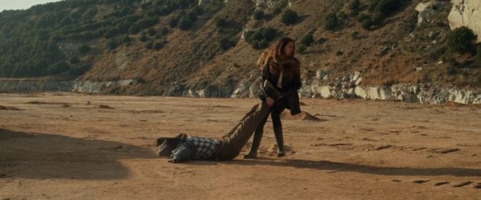 Helena drags a body through a deserted location