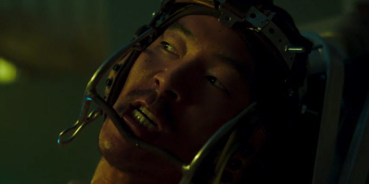 Leonardo Nam grits his teeth trying to resist the device that is attached to his head