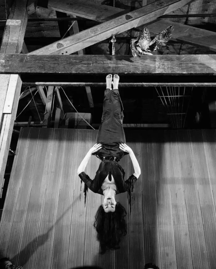 Maila Nurmi as Vampira hanging by her feet from rafters.