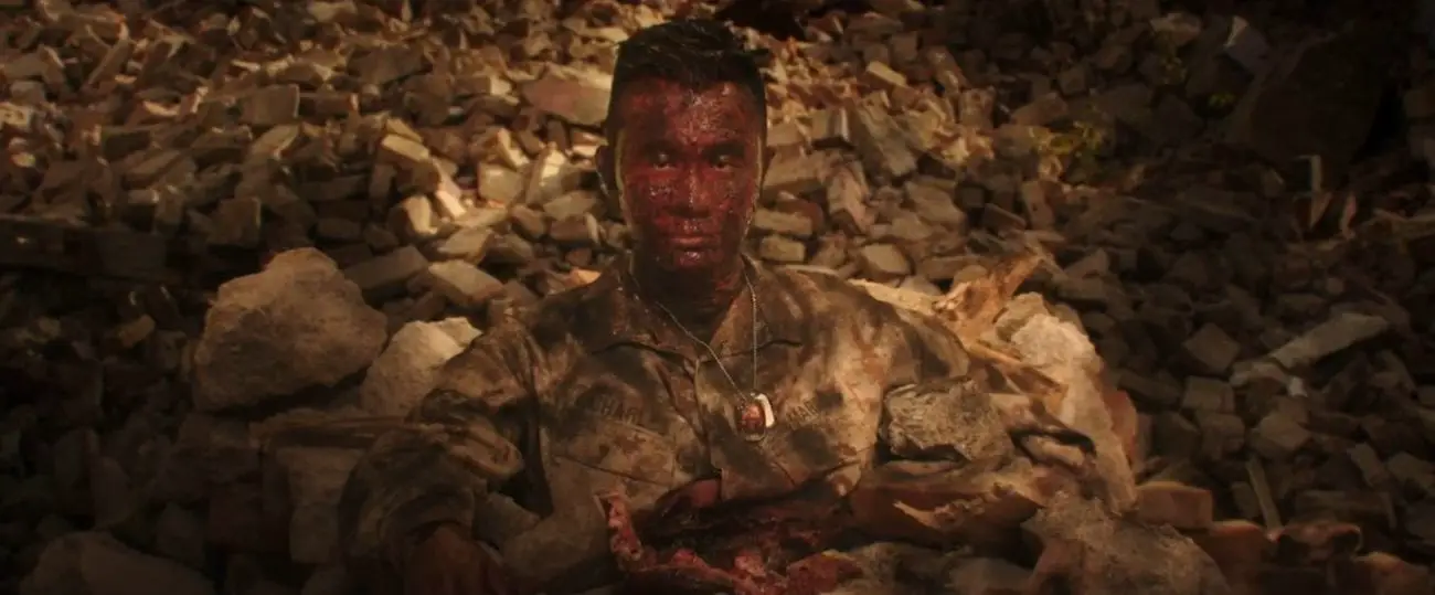 A dead man looking burned and lying in a pile of rubble