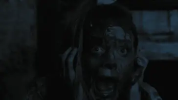 Jamie holds her hands over her ears while screaming with her face covered in blood