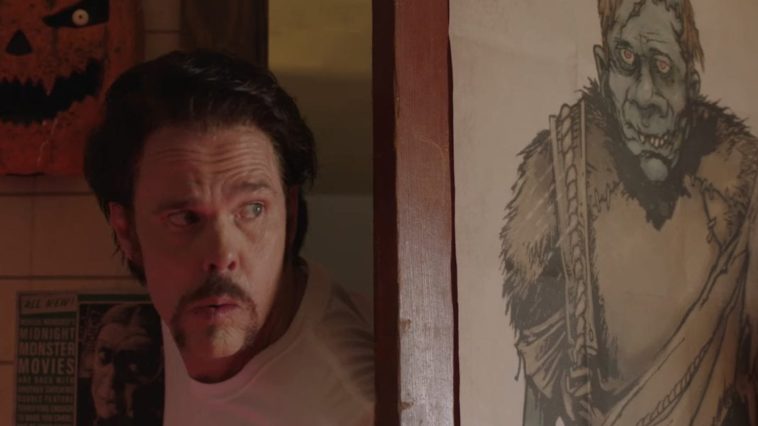 Kevin slides his head into Joe's room and looks around. A poster of Frankenstein hangs on the door.