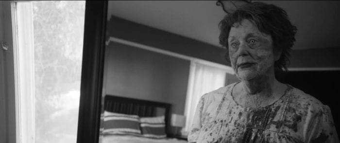 Suzanne appears before a mirror, her nightgown is covered in blood and her eyes are unnatural