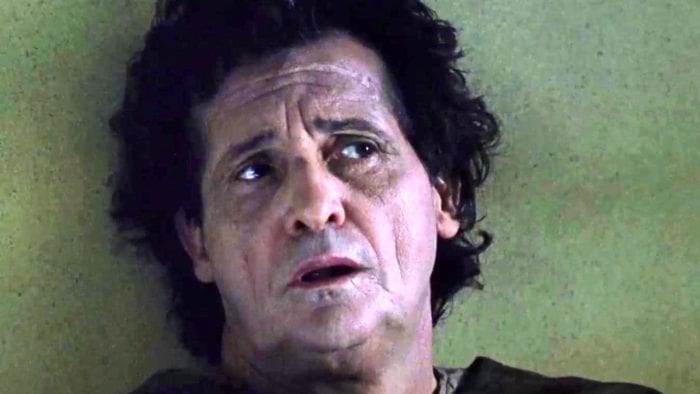 A close up of a disheveled man with a distressed look on his face.