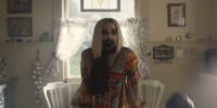 Anne stands in kitchen, pale as a ghost with darkened eyes and black rot forming around her mouth