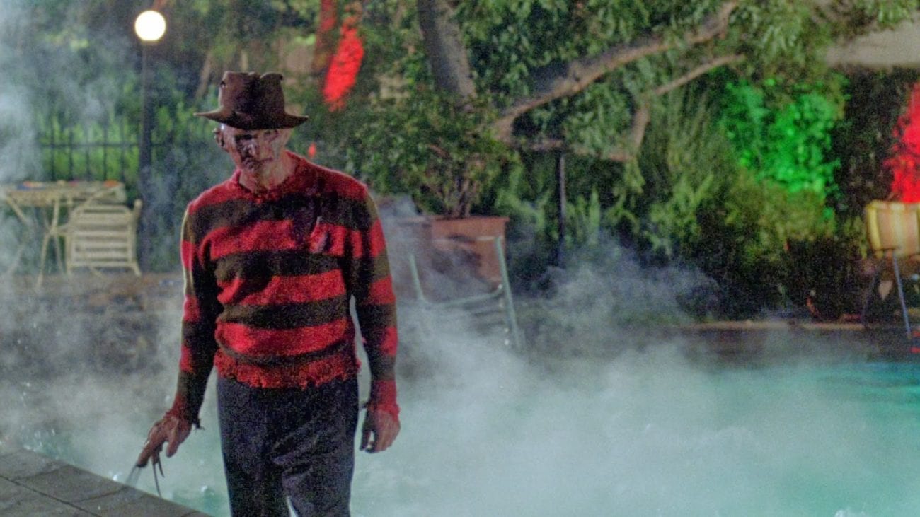 Freddy Krueger stands menacingly in a foggy back yard before a pool.