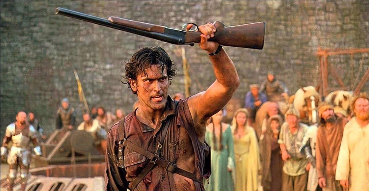 Ash raises his shotgun above his head in Army of Darkness.