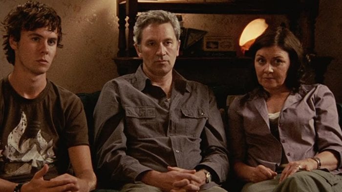 Matthew, Russell and June Palmer sit on a couch speaking to the camera