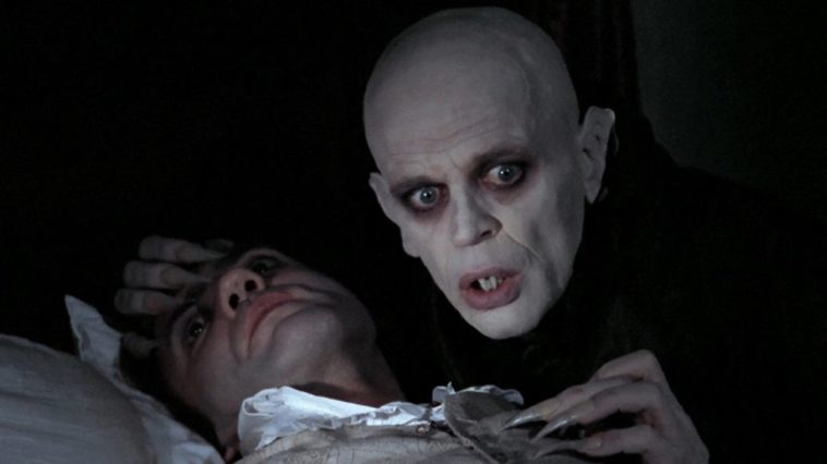 Dracula holding Jonathan Harker and looking concerned