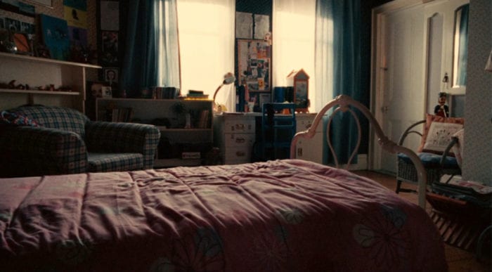 A shot of an empty teenager's bedroom, the sun streaming in through the window.