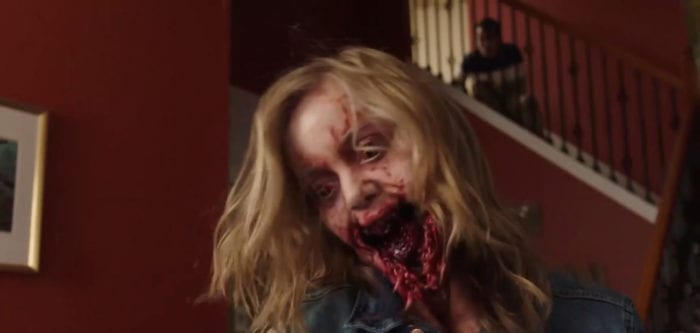 Lola Pierce (Maddie Nichols) opens her mouth in vampiric bloodthirst while her brother, Andrew (Andrew Brodeur), watches from the stairs behind her, from the TV show, "Creepshow."