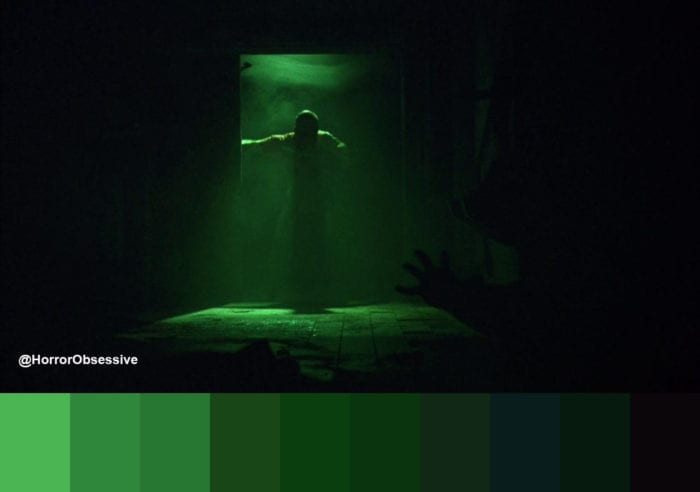 Jigsaw, illuminated by green light, closes a heavy door