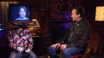 Joe Bob sitting and talking to Eli Roth on a monitor