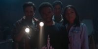 Brian, Alex, Louis, and Jess look toward the camera shining flashlights