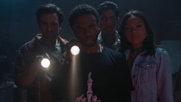 Brian, Alex, Louis, and Jess look toward the camera shining flashlights
