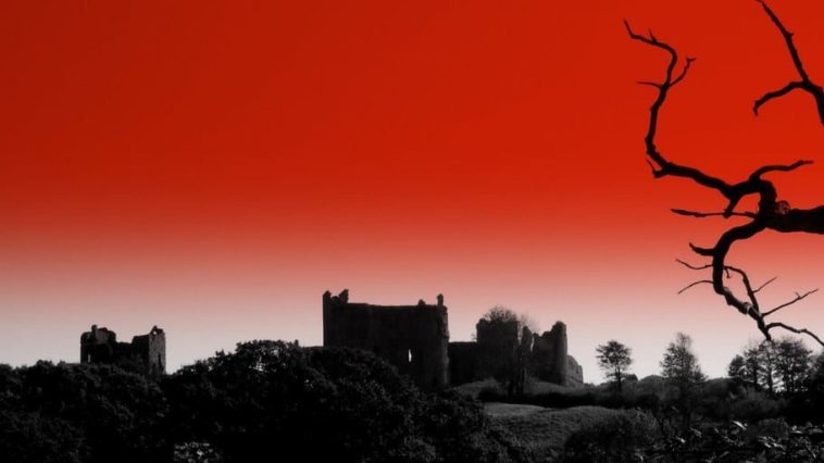 Red sky background behind a gothic building.