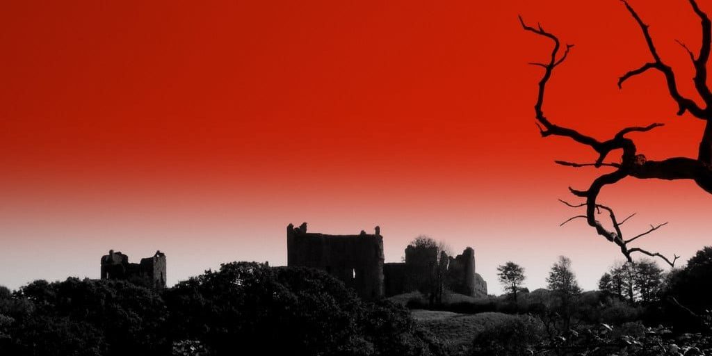 Red sky background behind a gothic building.