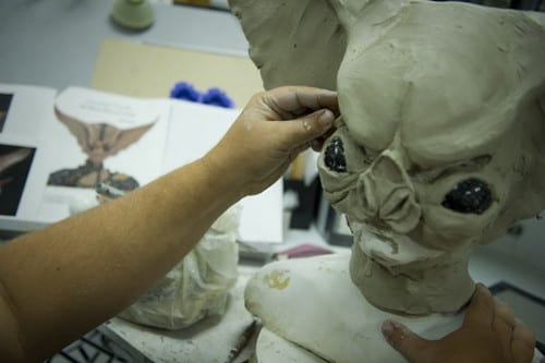 Person adding the finishing touches on a goblin prosthetic head
