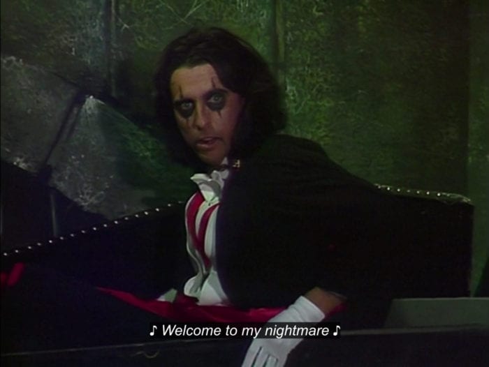 Alice Cooper sits up in a coffin, dressed as a vampire, singing, "Welcome to my nightmare," in the TV show, "The Muppet Show."
