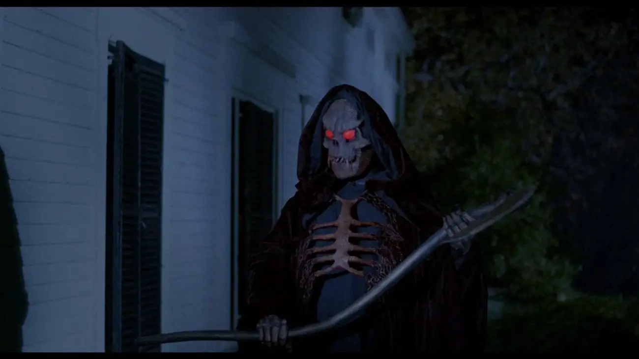 Grim Reaper standing outside a house with scythe in hand