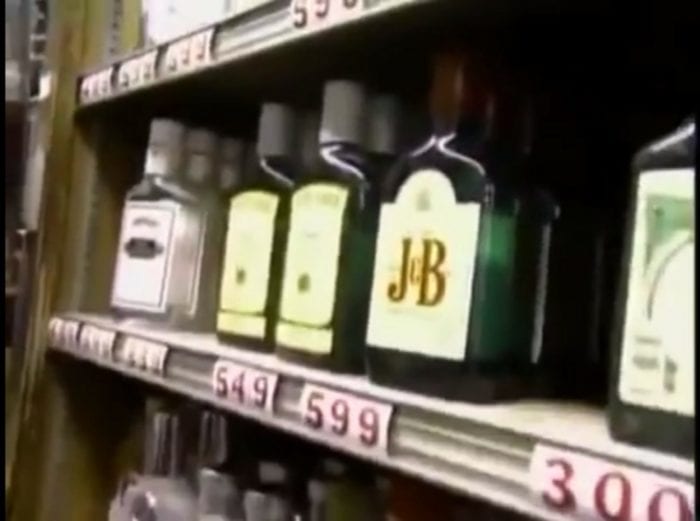 A shelf in a store filled with bottles of various types of alcohol.