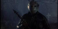 Jason Voorhees (C.J. Graham) standing in a cemetery at night in the rain. He is holding some sort of spear-type metal object.