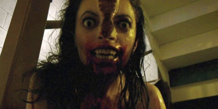A woman's face is splitting in two as she looks threateningly into the camera in V/H/S