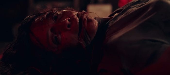 a woman lies bound, gagged, and bloody on the cabin floor