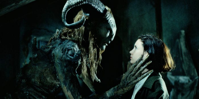 Doug Jones as The Faun or The Pale Man caresses a child's face in Pan's Labyrinth.