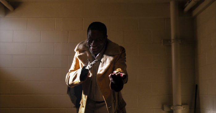 Candyman beckons to the viewer in a windowless room.
