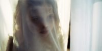 A ghostly girl seen through a thin curtain