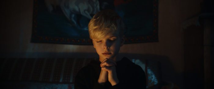 A boy folding his hands in prayer
