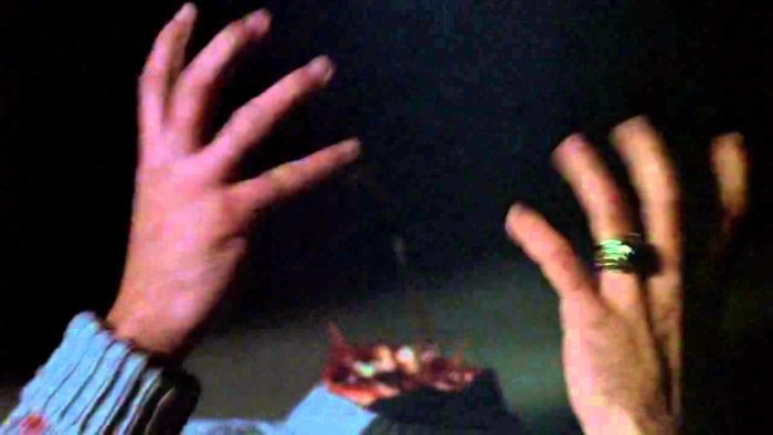Pamela Voorhees' beheaded body in a close-up with hands upraised.