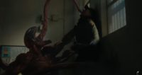 Carnage choking a guy with his symbiote appendages