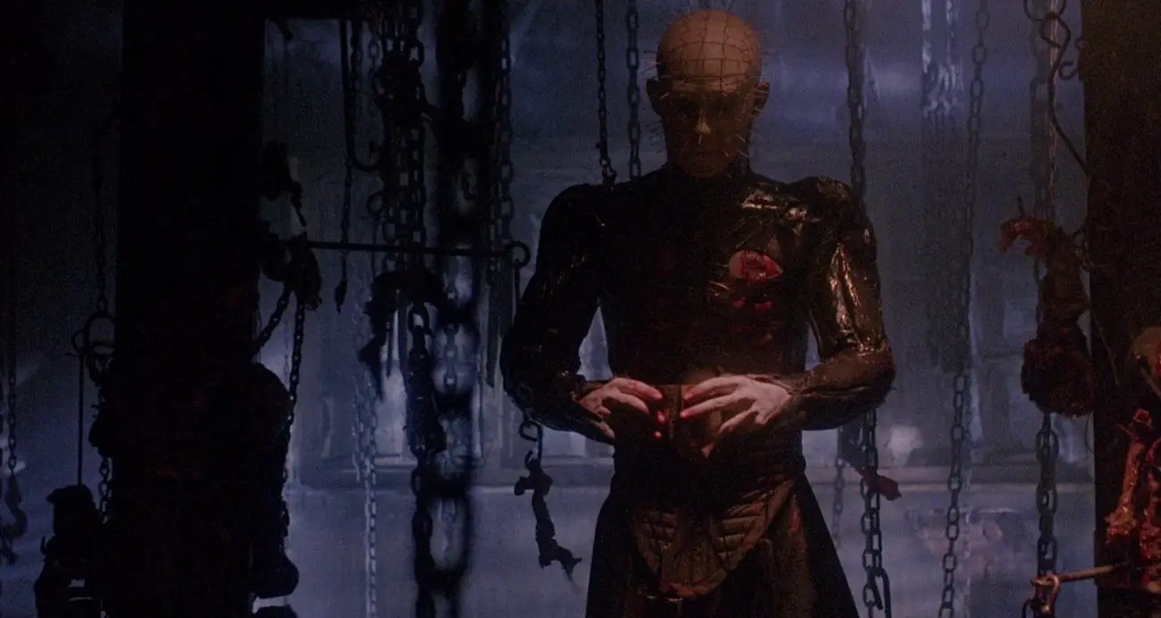 Pinhead holds the Lament Configuration puzzle box, surrounded by chains