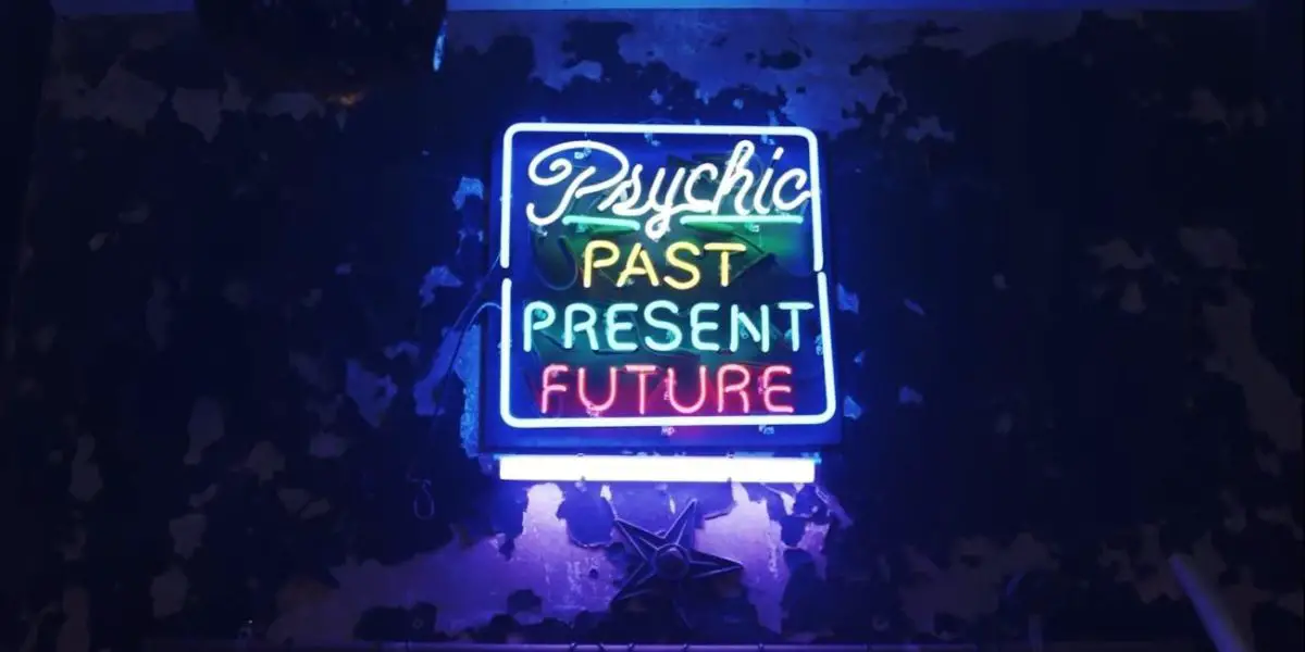 A neon sign eerily lit says "Psychic: Past, Present, Future