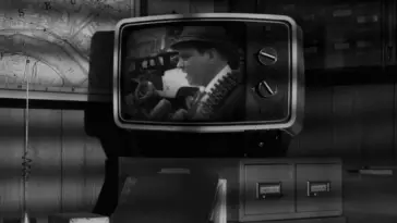 Black and white image of a vintage TV showing a news scene from "Night of the Living Dead."